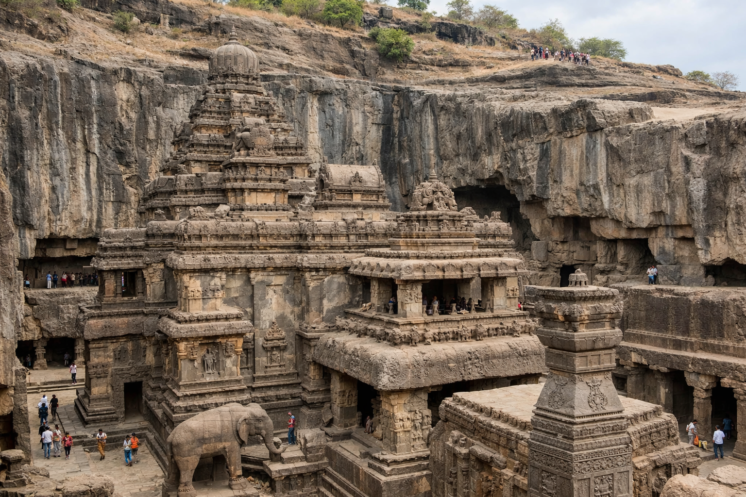 معبد كايلاسا المنحوت في صخر إلورا من منظور واسع يُظهر التفاصيل والنحت العميق داخل الجرف الصخري.